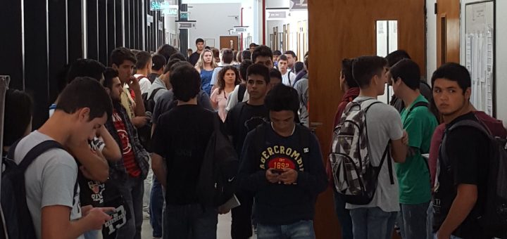 Imagen pasillo de la facultad donde se ven alumnos esperando para entrar a cursar